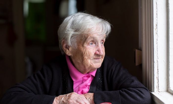Senior Adult: Lady Wearing Pink Looking Out the Window